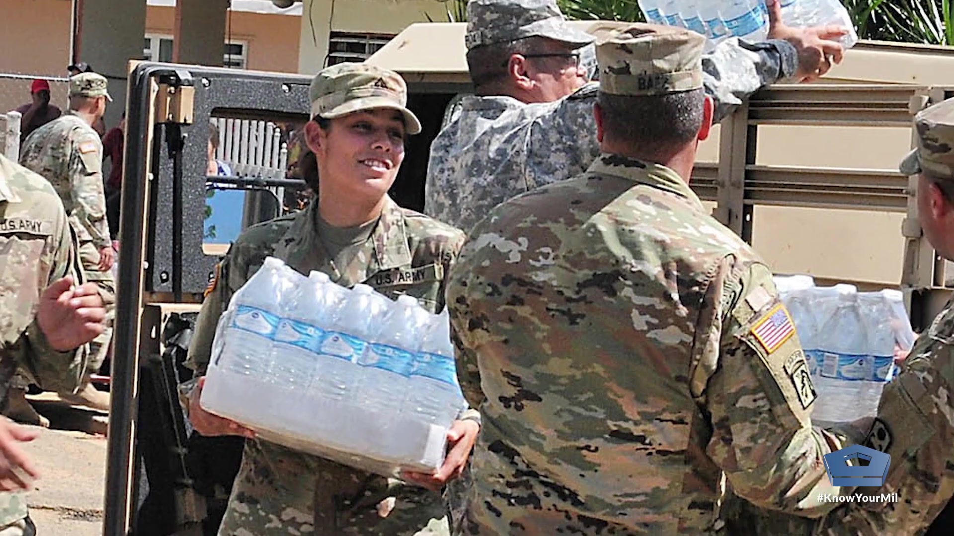 Service members help carry water.